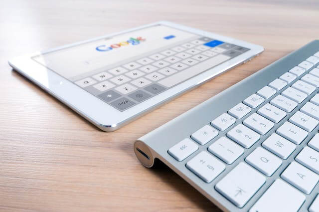 teclado y tablet con imagen de logo de google